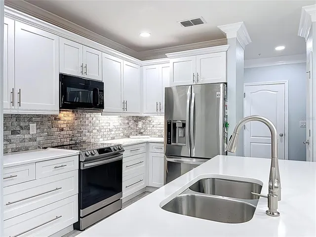 a kitchen with granite countertop a sink stove and refrigerator