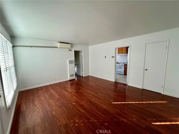 an empty room with wooden floor and closet