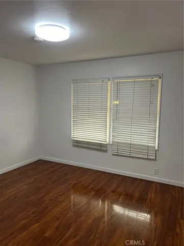 an empty room with wooden floor and door