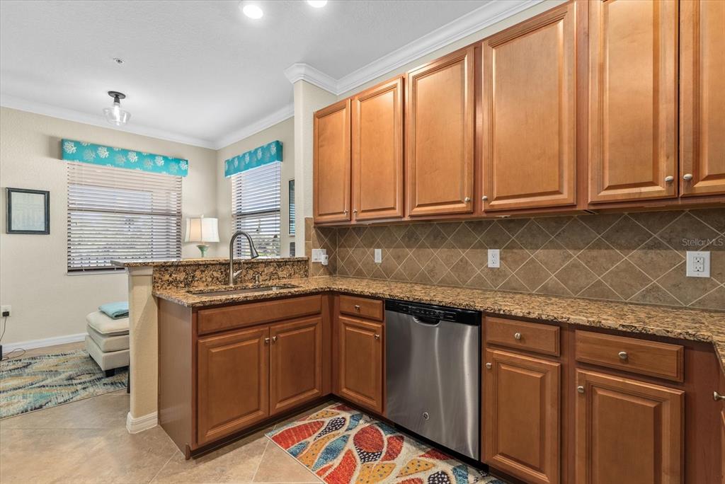 20080 Ragazza Circle, Unit 202 Venice, FL 34293 - Photo 12 of 51 a kitchen with stainless steel appliances granite countertop a sink stove and cabinets