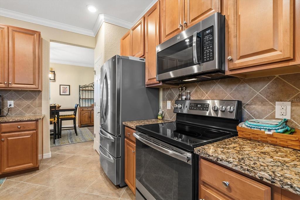 20080 Ragazza Circle, Unit 202 Venice, FL 34293 - Photo 15 of 51 a kitchen with stainless steel appliances granite countertop a stove microwave and refrigerator