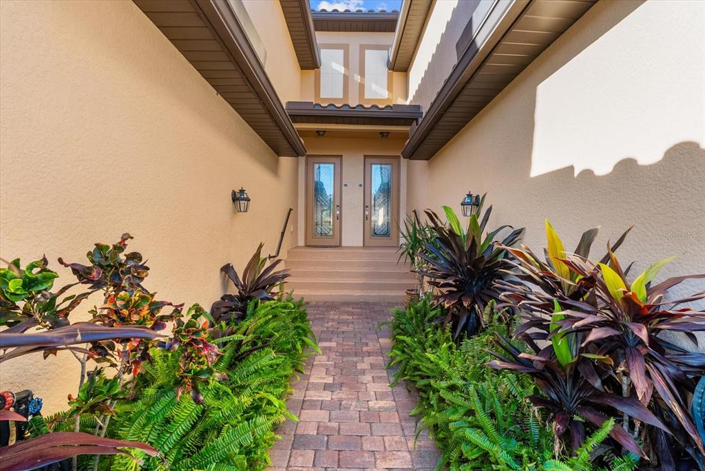 20080 Ragazza Circle, Unit 202 Venice, FL 34293 - Photo 36 of 51 a house with potted plants in front of it