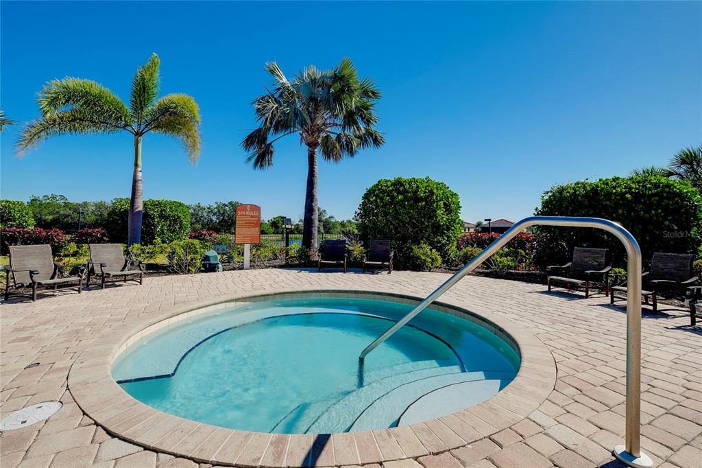 20080 Ragazza Circle, Unit 202 Venice, FL 34293 - Photo 46 of 51 a view of a swimming pool with a yard and palm trees