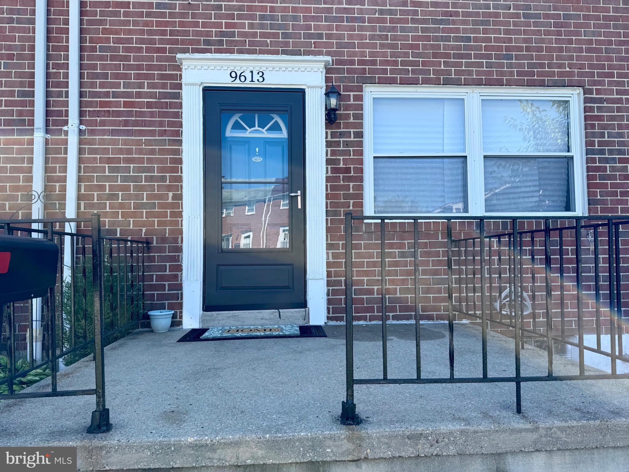 9613 Conmar Road Baltimore, MD 21220 - Photo 2 of 28 a brick building with a bench in front of door