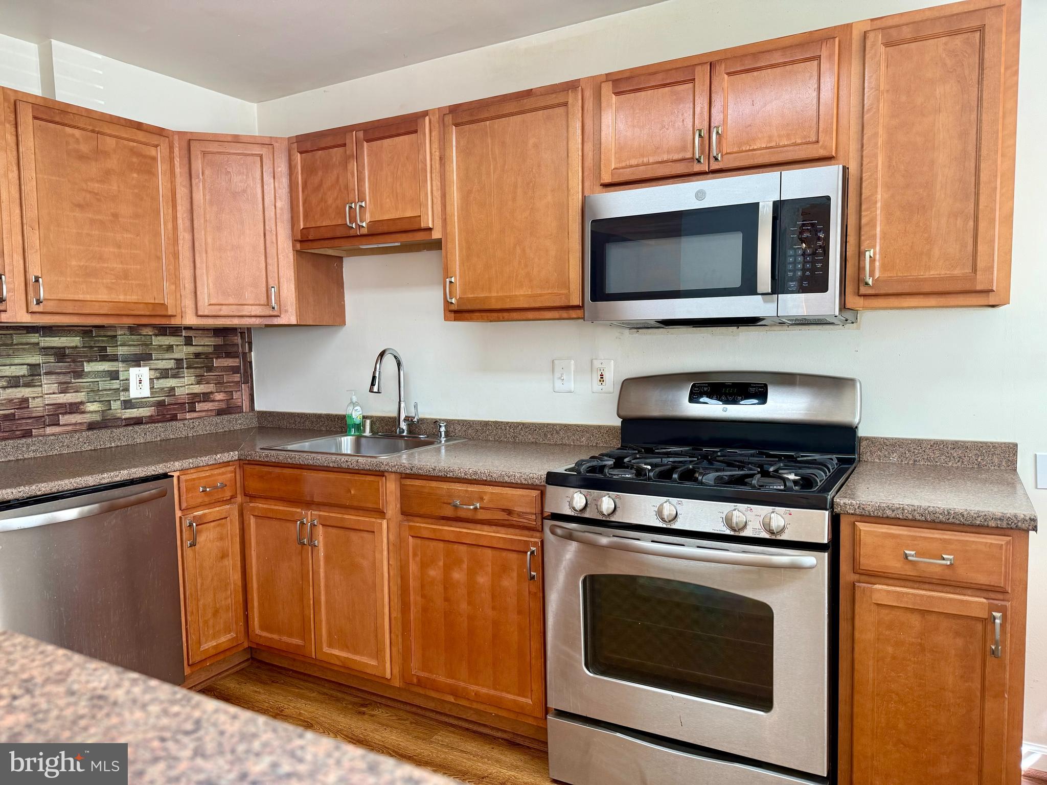 9613 Conmar Road Baltimore, MD 21220 - Photo 7 of 28 a kitchen with stainless steel appliances granite countertop a sink a stove a microwave oven and cabinets
