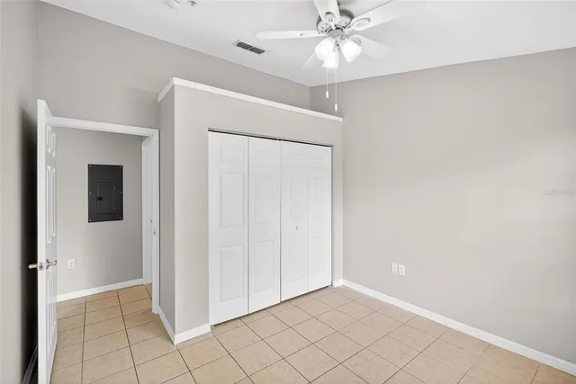 en empty room with windows and chandelier fan