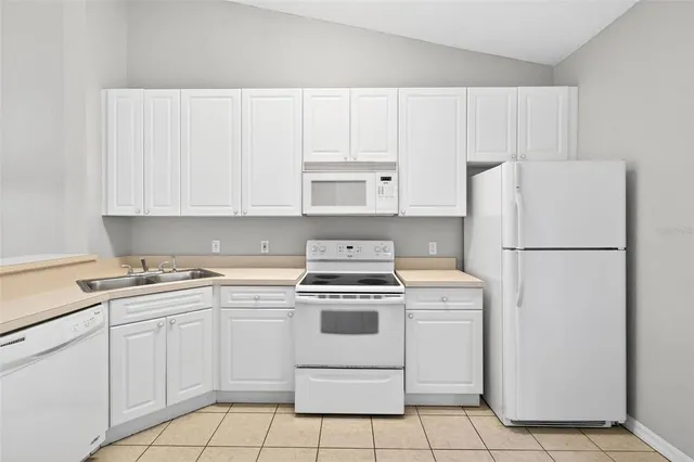 a kitchen with white cabinets and white appliances