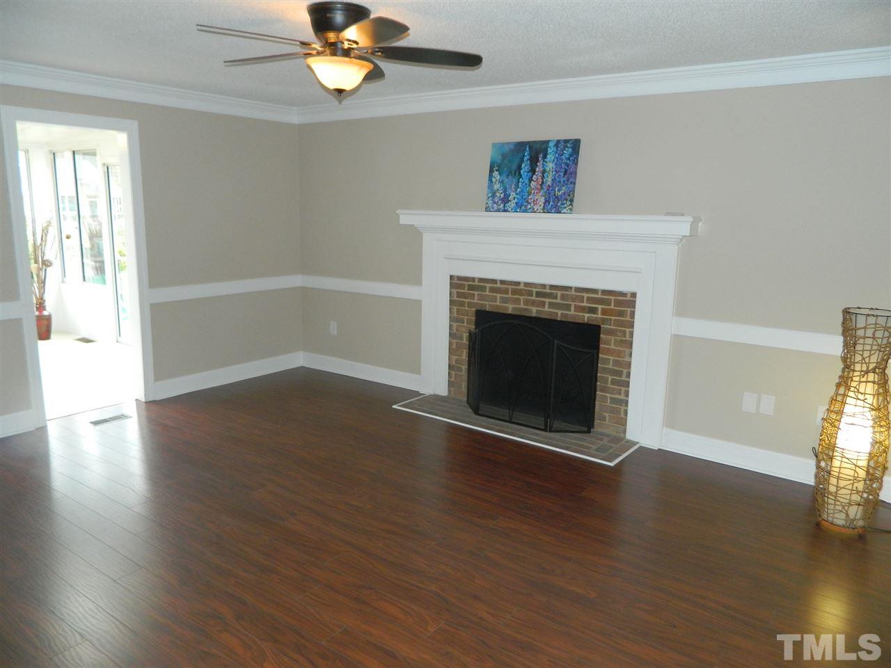 3824 Old Coach Road Raleigh, NC 27616 - Photo 4 of 25 a view of an empty room with wooden floor fireplace and a window