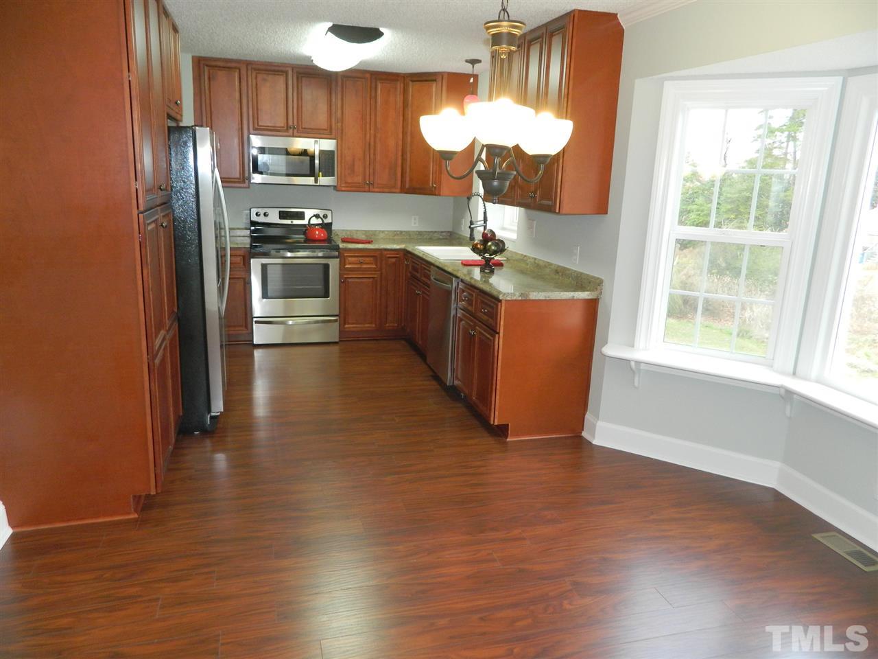 3824 Old Coach Road Raleigh, NC 27616 - Photo 6 of 25 a kitchen with stainless steel appliances a sink a refrigerator and wooden floor