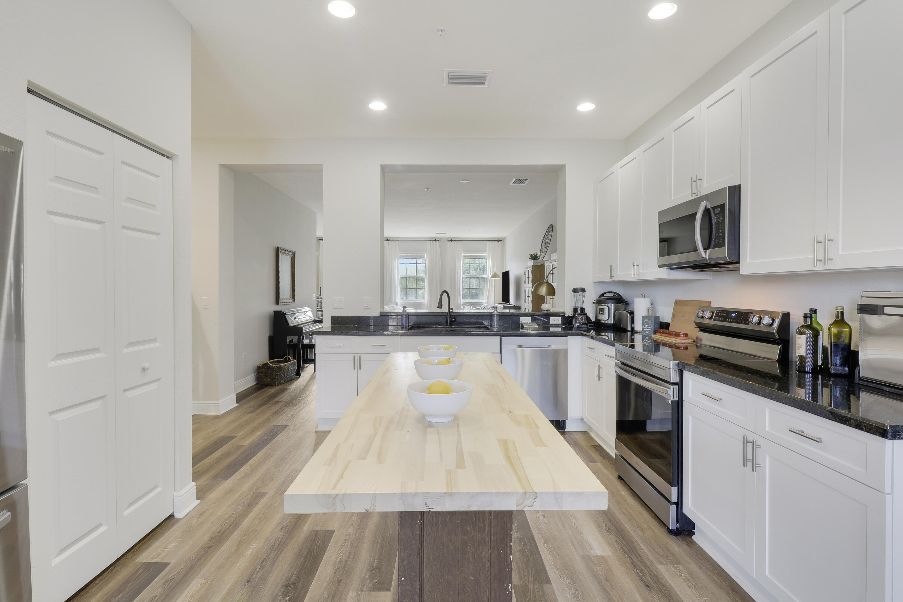 a large kitchen with cabinets a counter top space a sink and stainless steel appliances