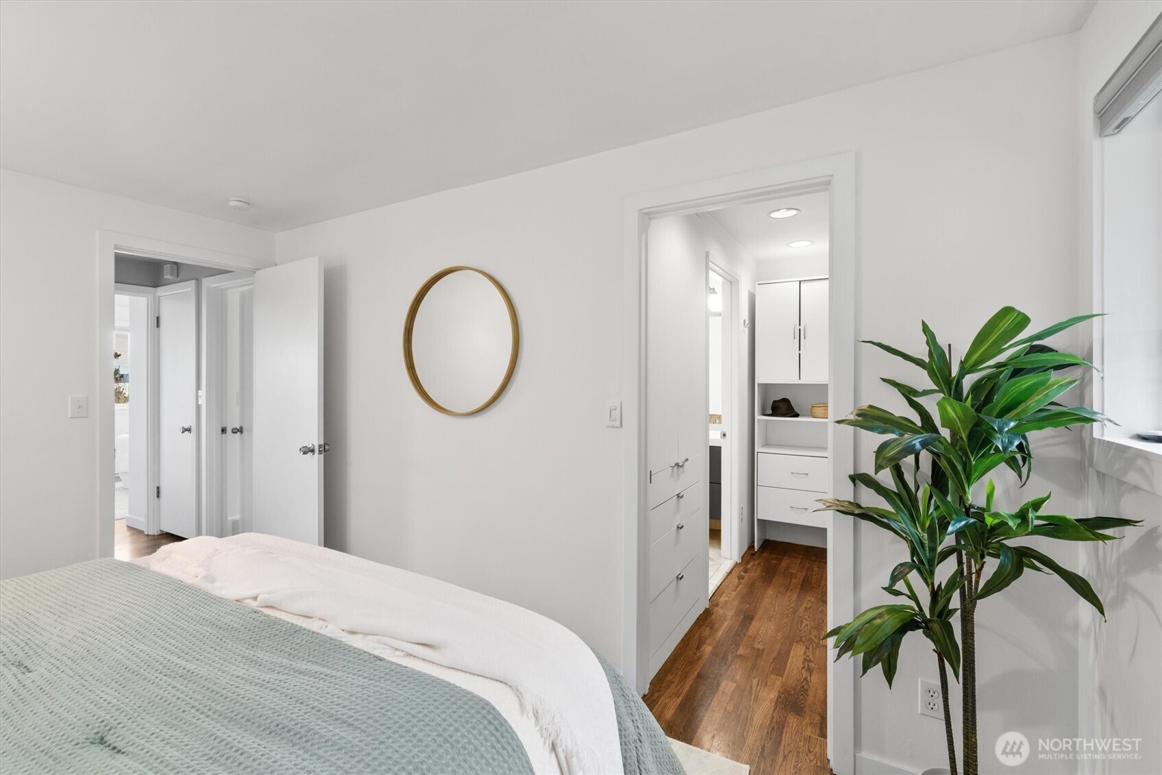 8620 Vashon View Southwest Seattle, WA 98136 - Photo 22 of 40 a bedroom with a potted plant and a wooden floor