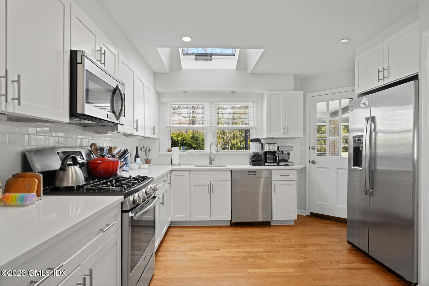 11 Manor Road Old Greenwich, CT 06870 - Photo 3 of 19 a kitchen with stainless steel appliances a sink a stove a refrigerator cabinets and a window