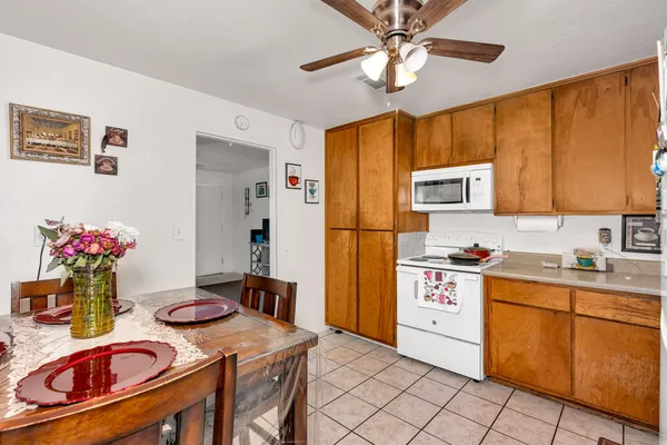 a kitchen with stainless steel appliances granite countertop a stove refrigerator a sink dishwasher and a dining table with wooden floor