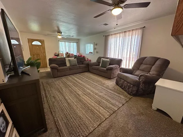 a living room with furniture ceiling fan and a window