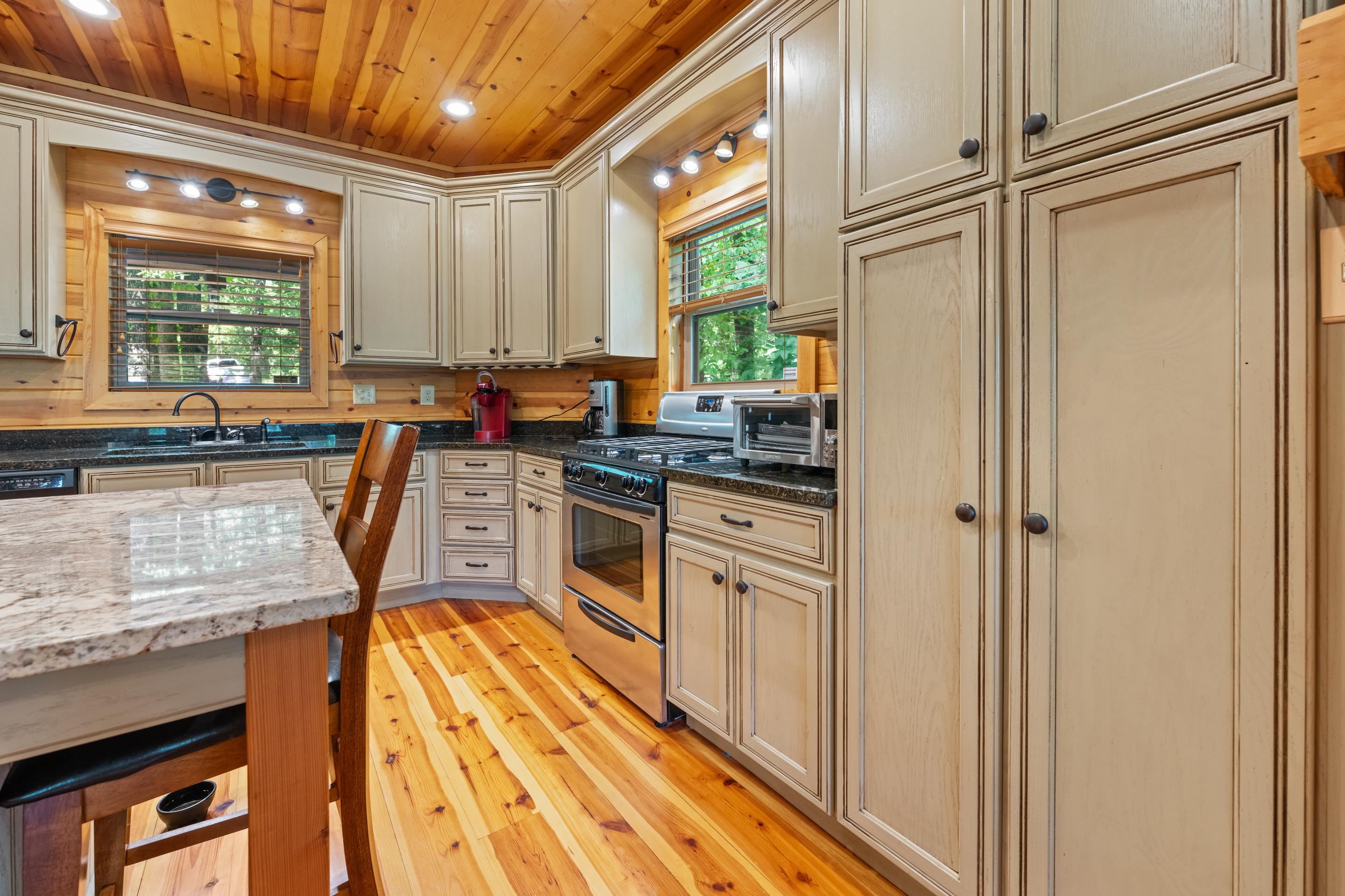 950 Cherry Road Eads, TN 38028 - Photo 5 of 30 Kitchen featuring wood-finish flooring, a wood-paneled ceiling, light-toned cabinetry, dark countertops, and stainless steel appliances