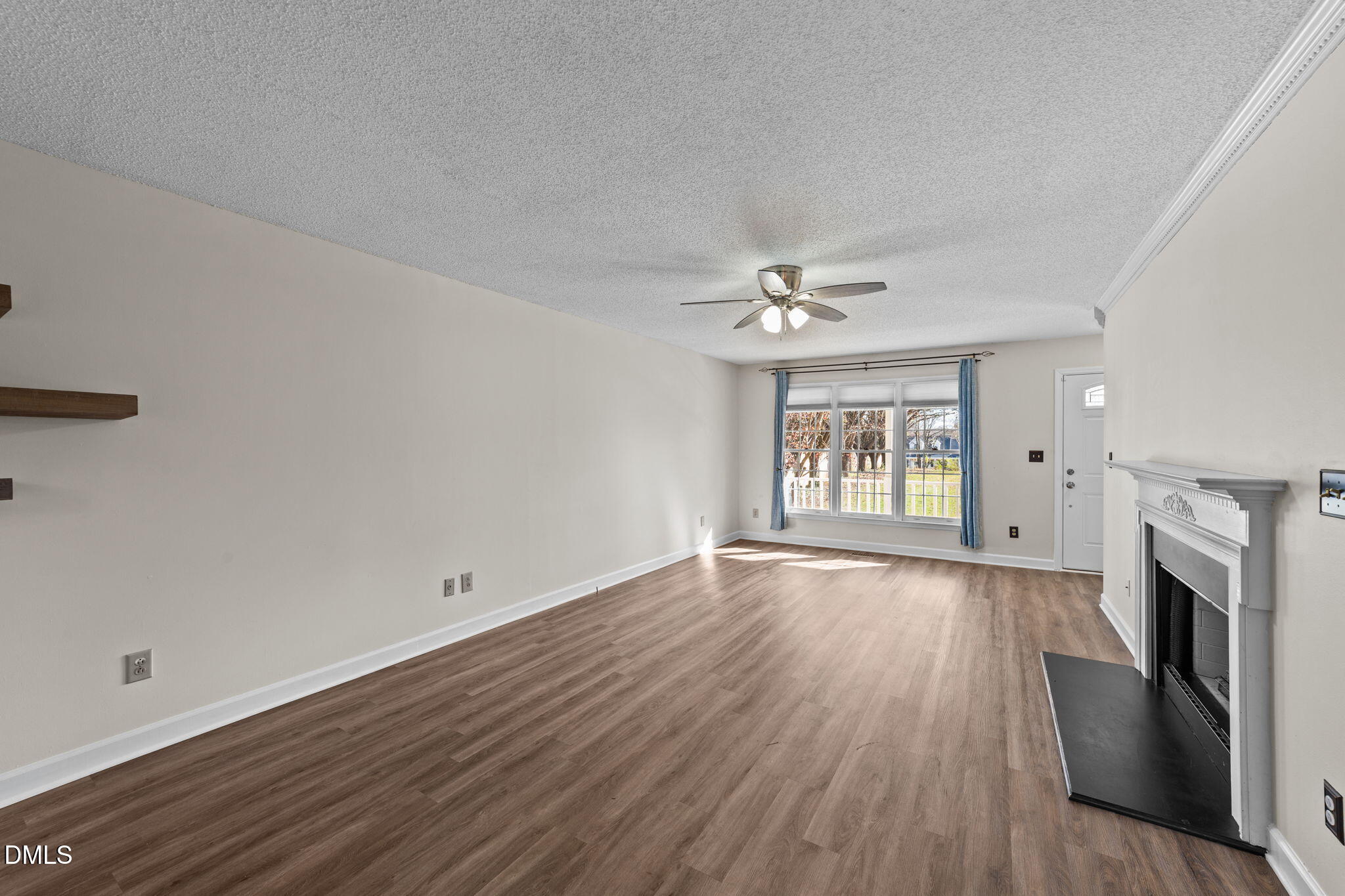 1030 Loop Road Clayton, NC 27527 - Photo 3 of 20 a view of an empty room with wooden floor fireplace and a window