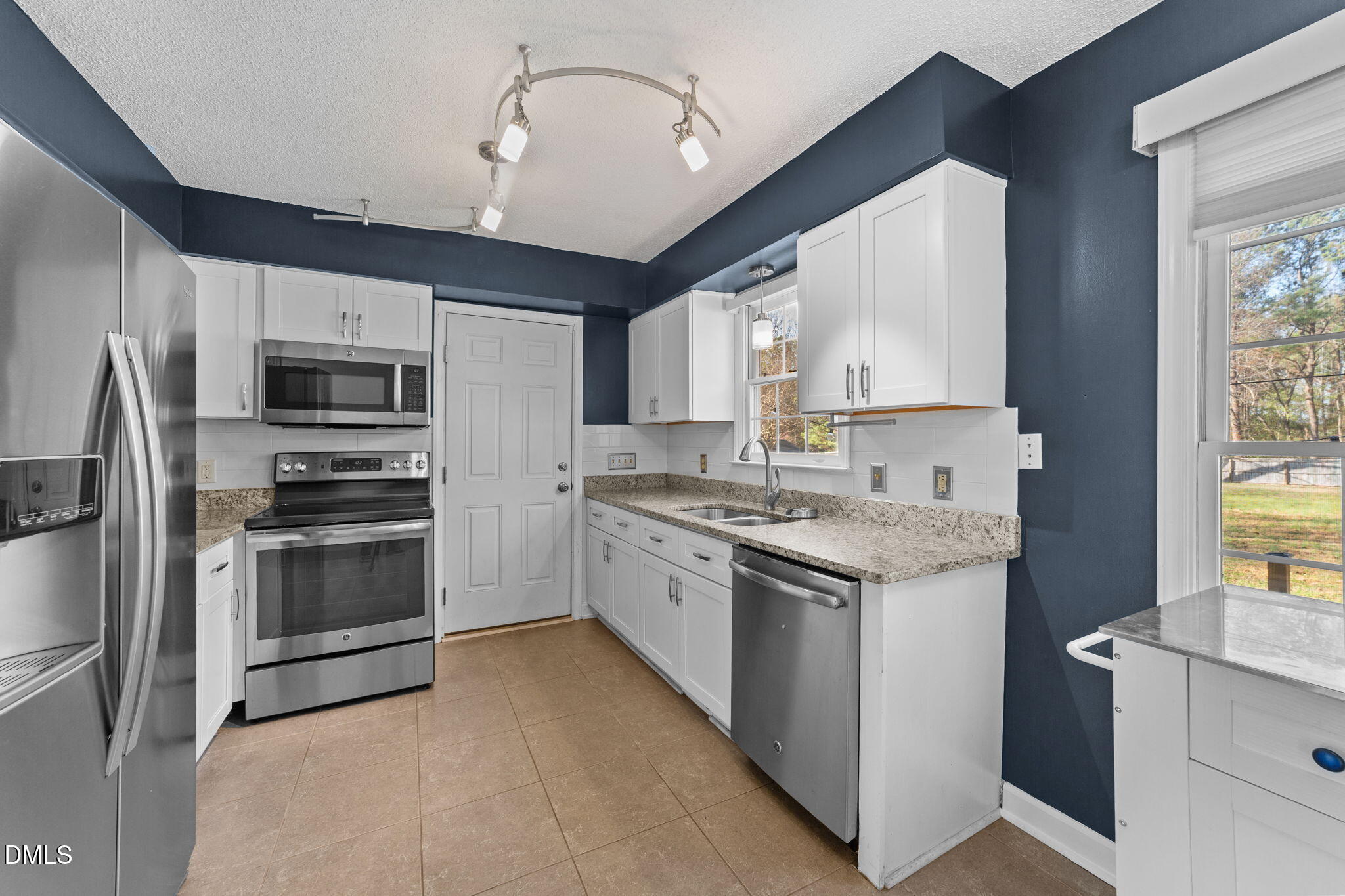 1030 Loop Road Clayton, NC 27527 - Photo 7 of 20 a kitchen with stainless steel appliances granite countertop a stove top oven a sink and a refrigerator