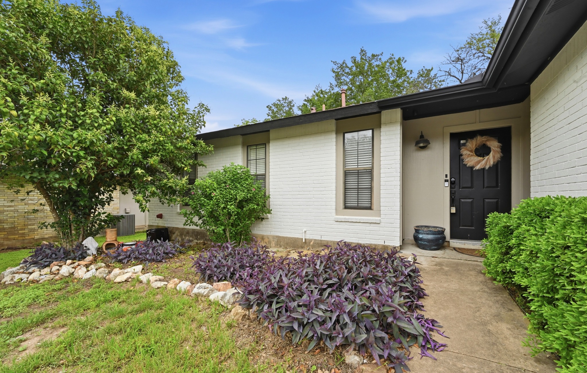 6805 Rearden Road Austin, TX 78745 - Photo 2 of 26 A welcoming entry framed by lush landscaping leads to this charming residence.