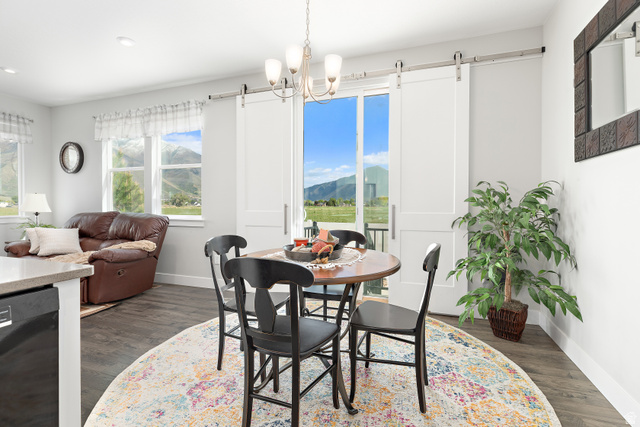 2343 Wysteria Drive Mapleton, UT 84664 - Photo 12 of 30 Dining space with a mountain view, a barn door, dark wood-style floors, and a chandelier