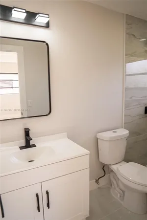 a bathroom with a toilet sink and mirror