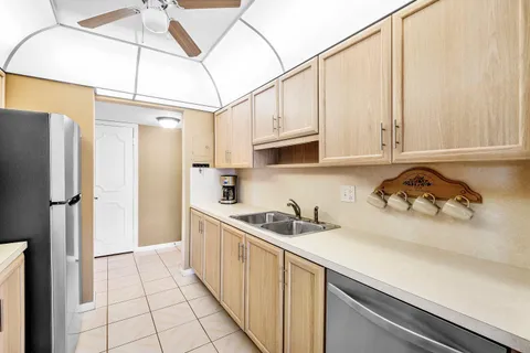 a kitchen with stainless steel appliances granite countertop a sink a refrigerator and cabinets