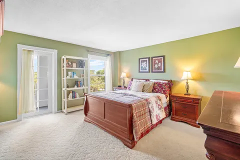 a spacious bedroom with a bed and wooden floor