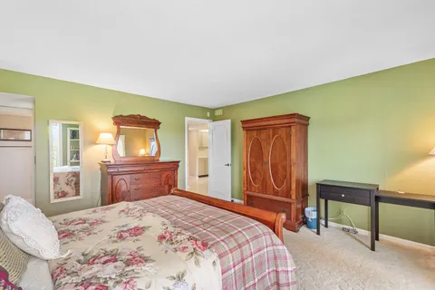 a bedroom with a bed and dresser with mirror