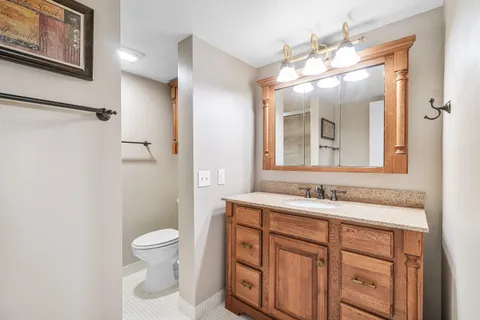 a bathroom with a toilet sink and mirror