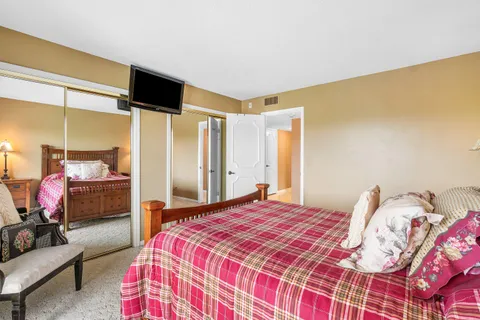 a bedroom with a bed wooden floor and a window