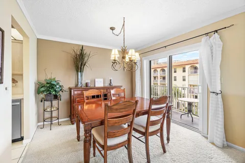 a dining room with furniture a chandelier and window