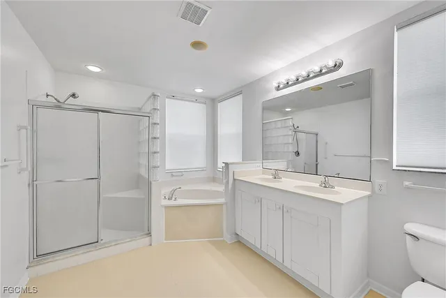 a bathroom with a double vanity sink mirror and toilet