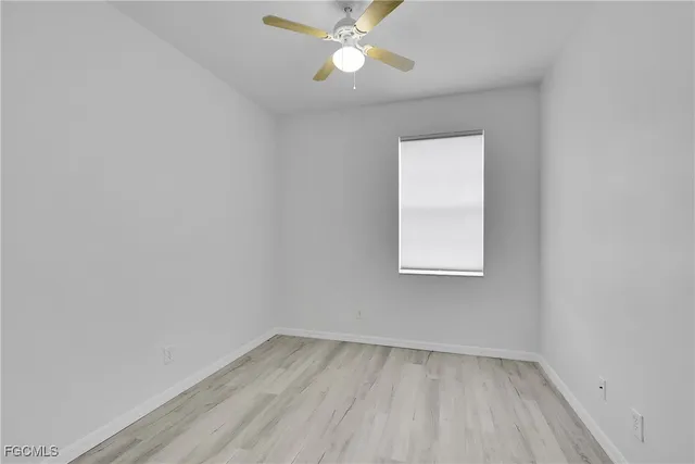 an empty room with a window and wooden floor