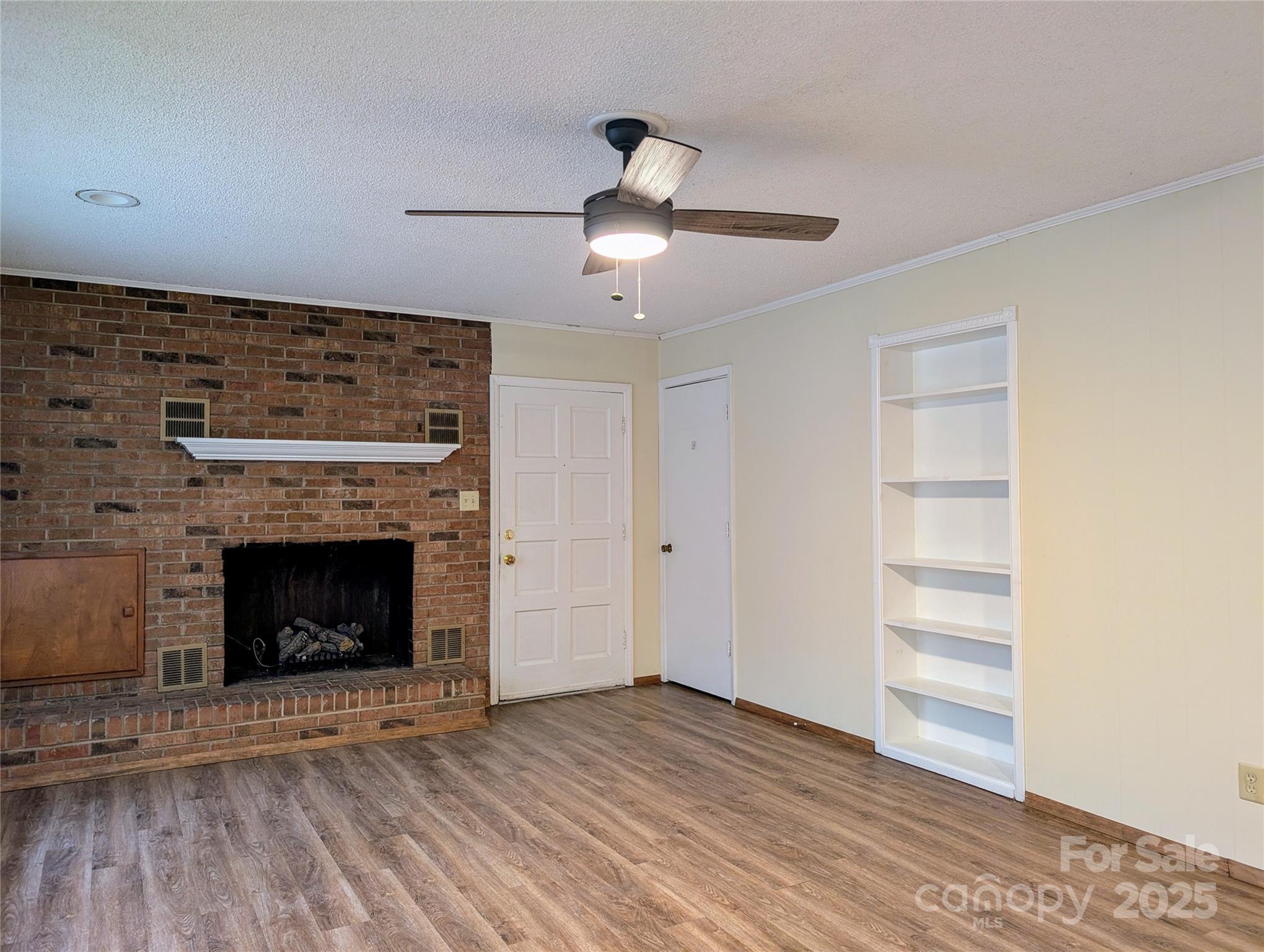 5628 White Store Road Wingate, NC 28174 - Photo 11 of 31 a view of an empty room with wooden floor fireplace and a window