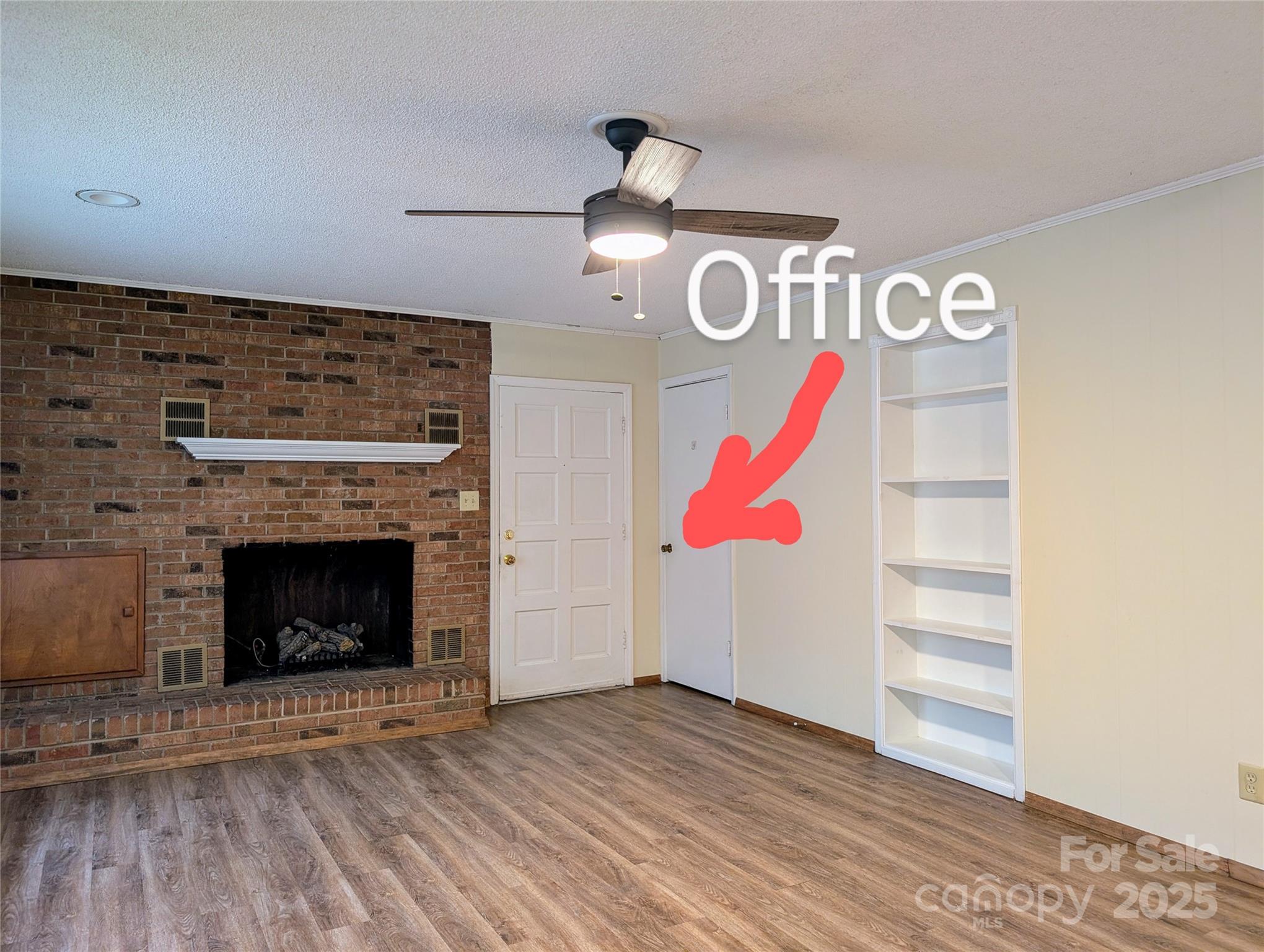5628 White Store Road Wingate, NC 28174 - Photo 12 of 31 a view of an empty room with wooden floor and a fireplace
