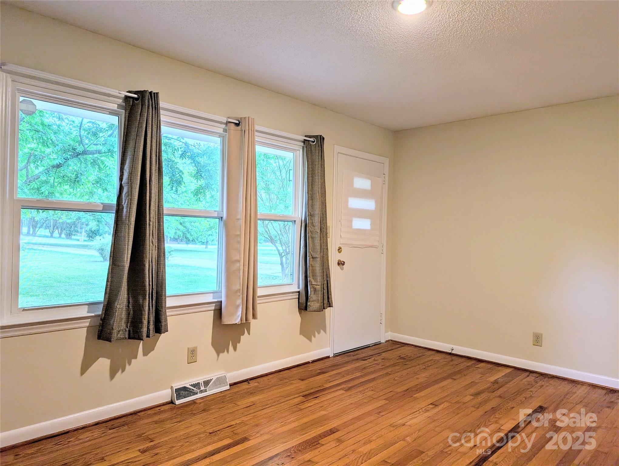 5628 White Store Road Wingate, NC 28174 - Photo 22 of 31 an empty room with wooden floor and windows
