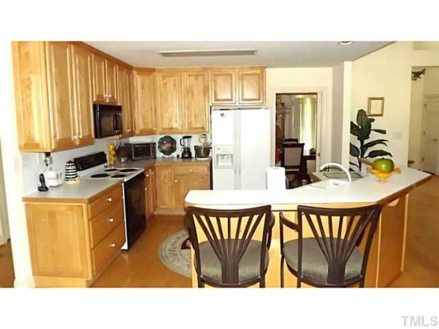 6671 Old Fairground Road Benson, NC 27504 - Photo 16 of 25 a kitchen with stainless steel appliances a dining table chairs and granite counter tops