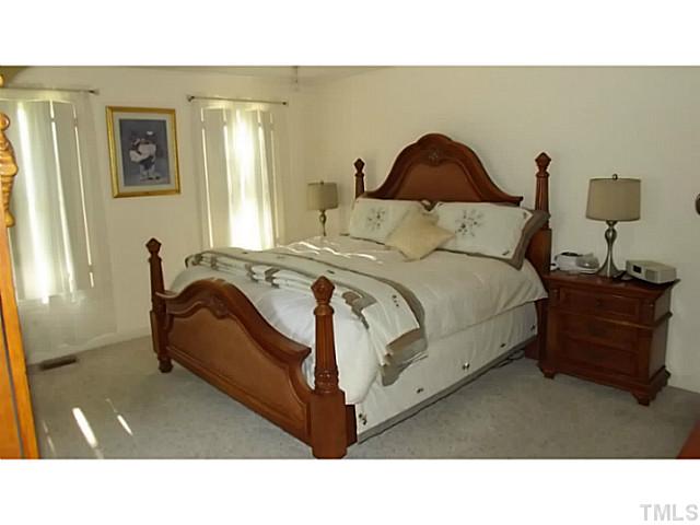 6671 Old Fairground Road Benson, NC 27504 - Photo 18 of 25 a bedroom with a bed and wooden floor