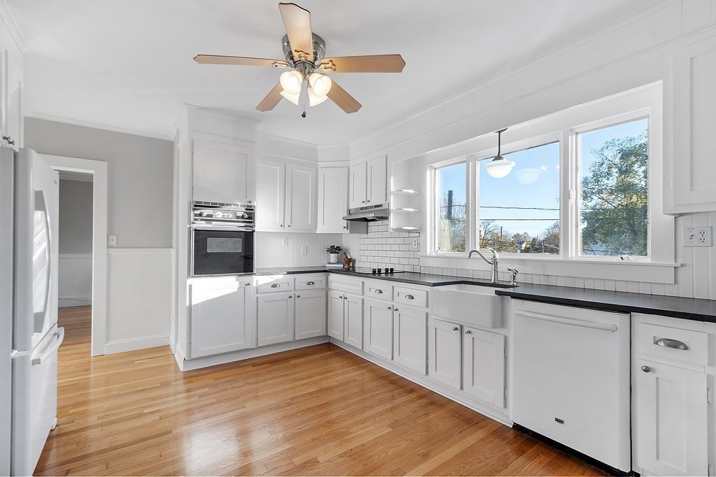 10 Victoria Road, Unit 2 Arlington, MA 02474 - Photo 14 of 28 a large kitchen with cabinets wooden floor and stainless steel appliances