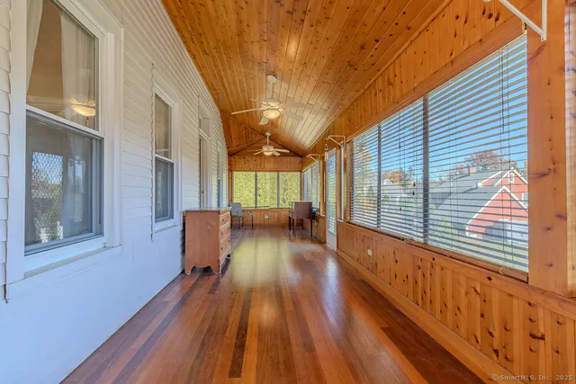 a bedroom with a flat screen tv on the dresser and a window