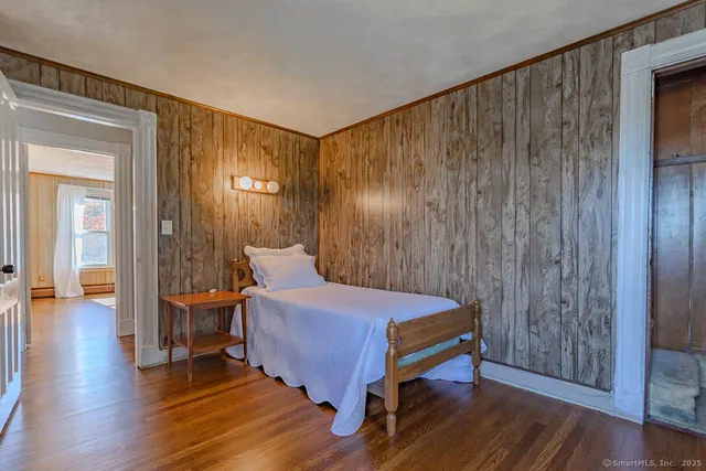 a bedroom with a bed and wooden floor