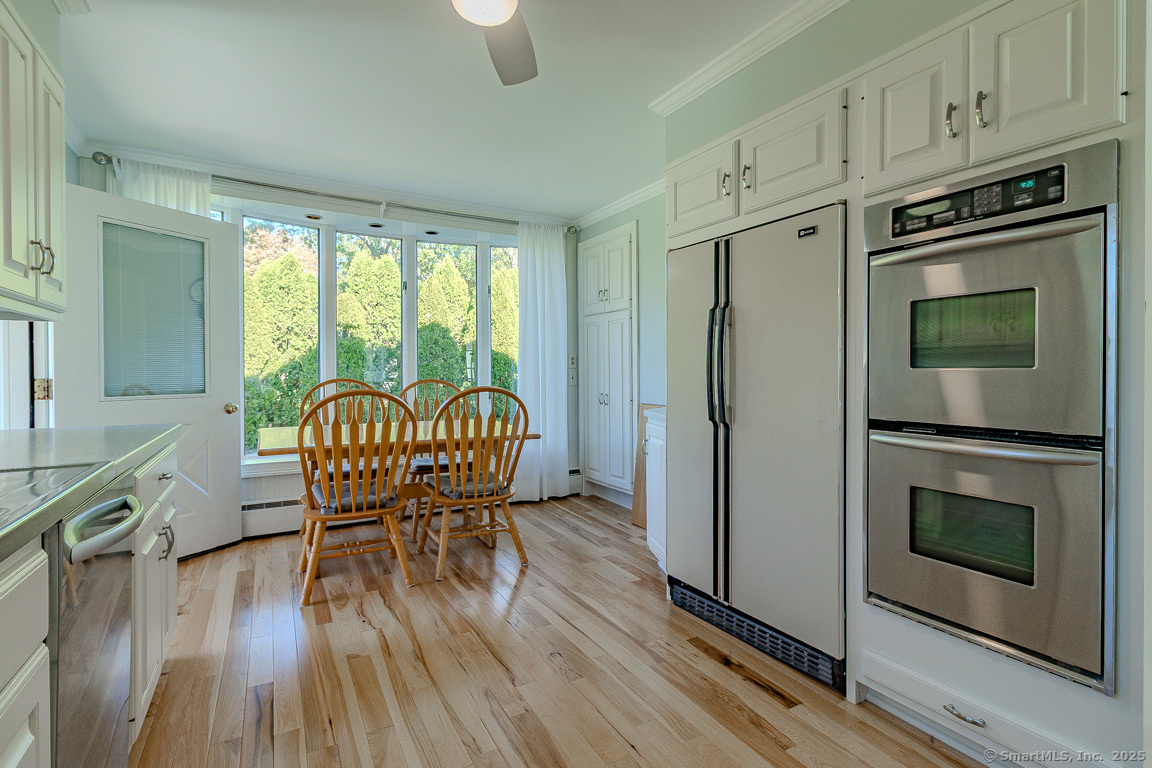 1152 Worthington Ridge Berlin, CT 06037 - Photo 6 of 40 a kitchen with stainless steel appliances granite countertop a stove a refrigerator a microwave oven with a dining table and chairs with wooden floor