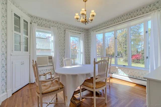 a view of a dining room with furniture a chandelier and wooden floor