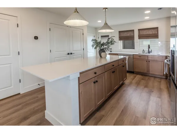 a large kitchen with a lot of counter space and wooden floor