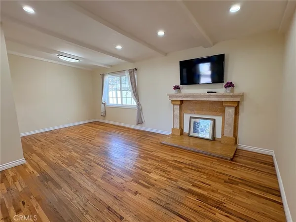a view of empty room with wooden floor and fireplace