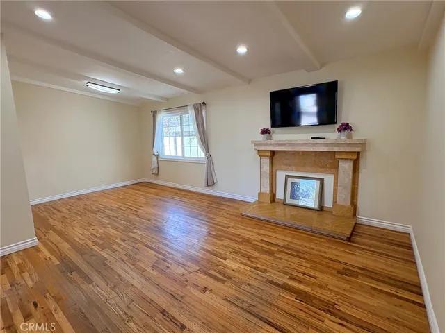 a view of empty room with wooden floor and fireplace
