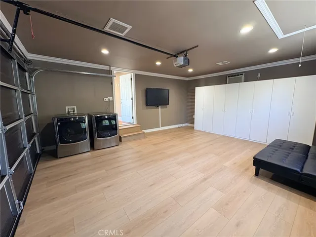 a view of an empty room with furniture and wooden floor