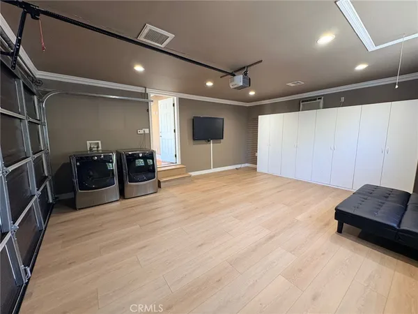 a view of an empty room with furniture and wooden floor