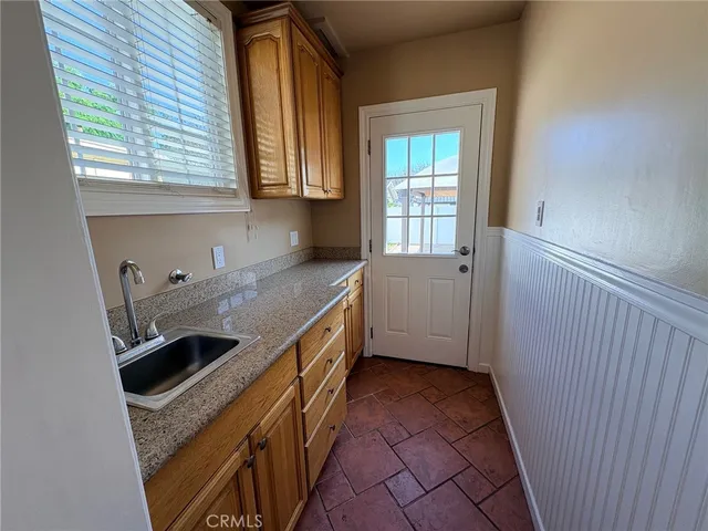a kitchen with granite countertop a sink a stove and cabinets