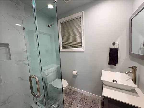 a bathroom with a sink a toilet and shower
