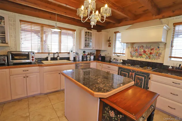 a kitchen with stainless steel appliances granite countertop a sink window and cabinets
